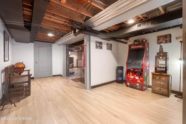 unfinished basement with visible vents, baseboards, and wood finished floors