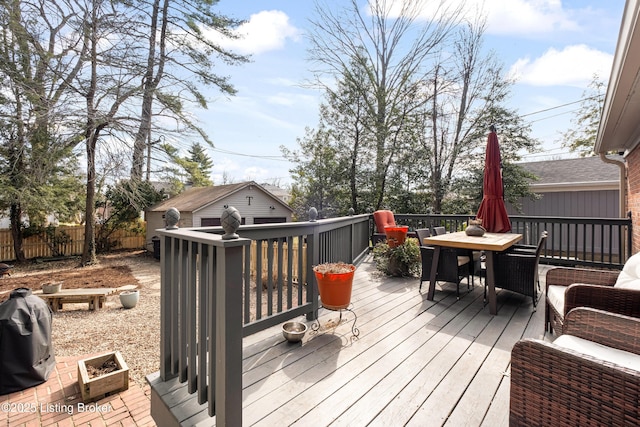 wooden terrace with outdoor dining space, a fire pit, and fence