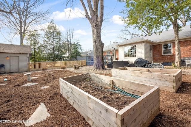 view of yard with an outbuilding, fence, and a garden