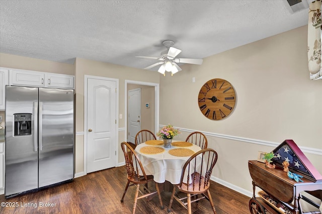 dining space featuring dark wood finished floors, visible vents, a textured ceiling, and ceiling fan