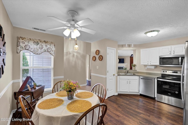 kitchen featuring visible vents, dark wood finished floors, appliances with stainless steel finishes, a textured ceiling, and white cabinetry