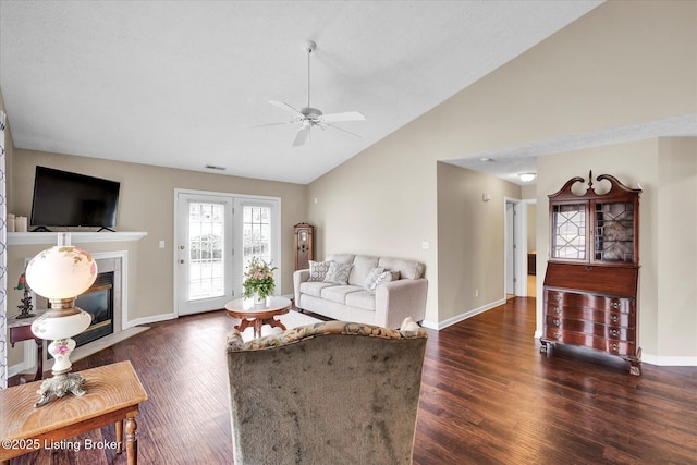 living room featuring visible vents, lofted ceiling, wood finished floors, and a tiled fireplace