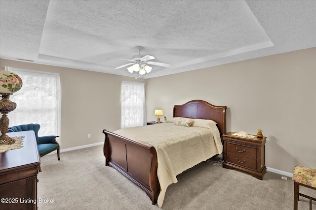 bedroom featuring baseboards, light carpet, a textured ceiling, and a ceiling fan