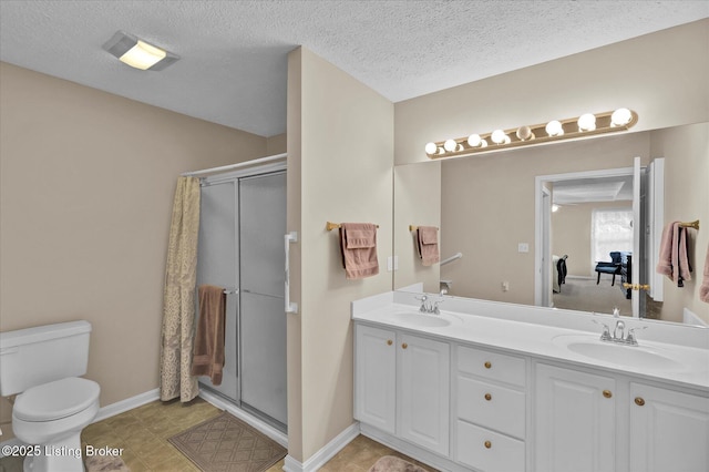 bathroom featuring a sink, toilet, a stall shower, and double vanity