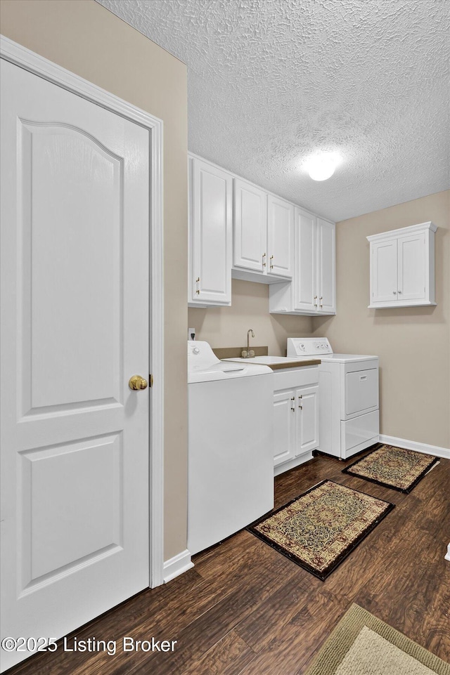 clothes washing area featuring baseboards, cabinet space, dark wood-style flooring, a sink, and washer and clothes dryer