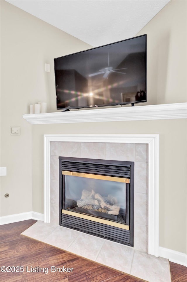 details with baseboards, wood finished floors, and a fireplace