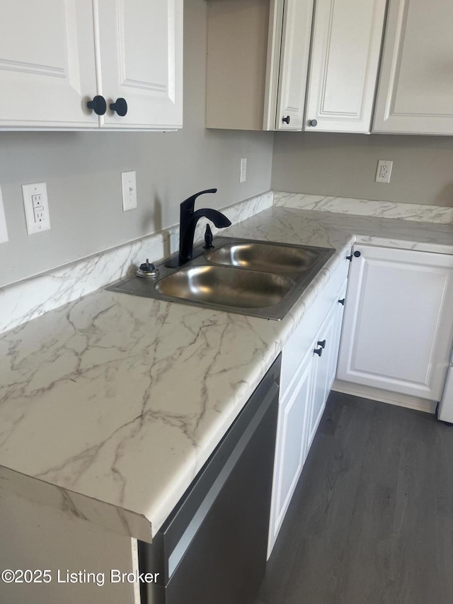 kitchen with dishwashing machine, white cabinets, and a sink