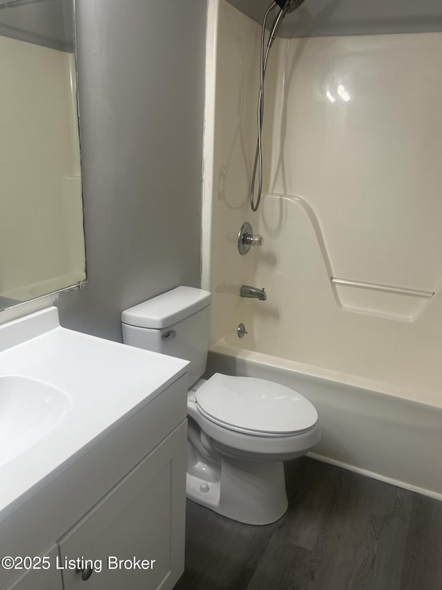 full bath featuring toilet, vanity, shower / bath combination, and wood finished floors