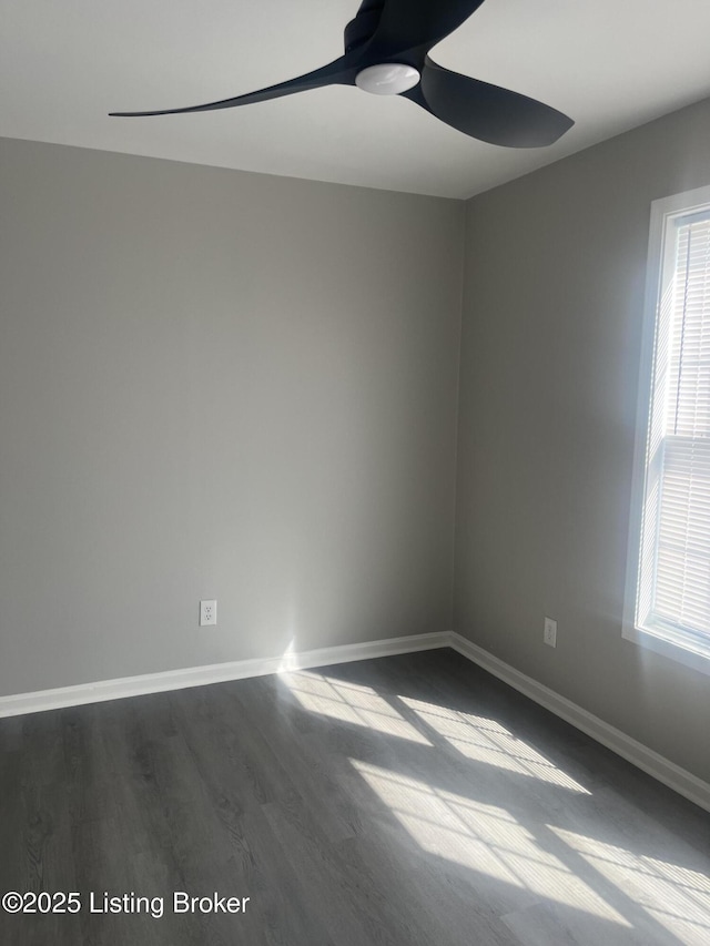 empty room featuring ceiling fan, dark wood-type flooring, and baseboards