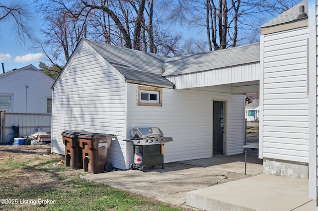 exterior space with a patio and roof with shingles