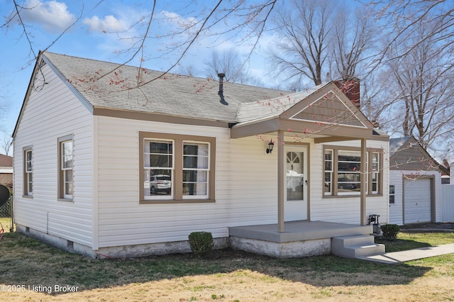 view of front of property with roof with shingles, covered porch, and a front lawn