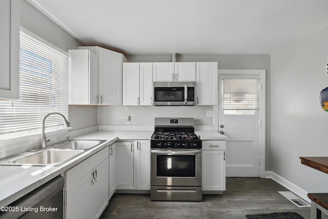 kitchen with white cabinetry, light countertops, appliances with stainless steel finishes, and a sink