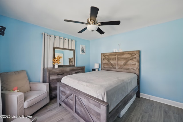 bedroom with ceiling fan, baseboards, and wood finished floors