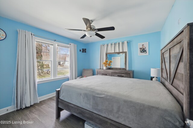 bedroom featuring ceiling fan, baseboards, and wood finished floors