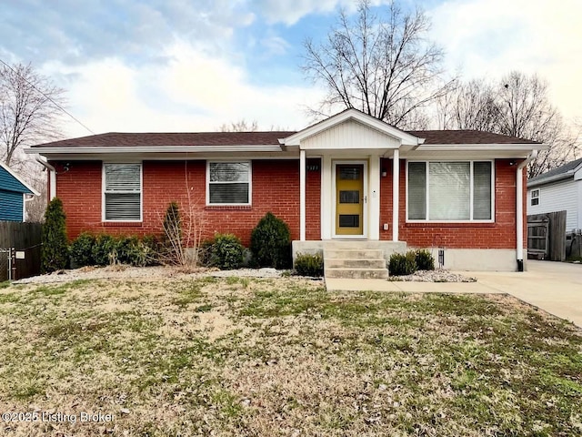 ranch-style home featuring a front lawn, fence, and brick siding