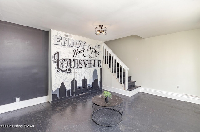 foyer entrance featuring stairs, wood finished floors, and baseboards