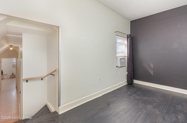 unfurnished room with cooling unit, baseboards, and dark wood-style flooring