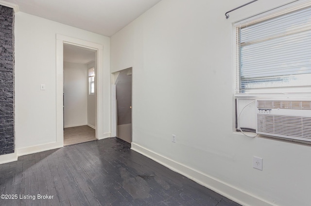 spare room with dark wood-type flooring, cooling unit, baseboards, and a wealth of natural light