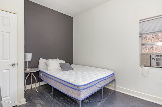 bedroom featuring cooling unit, baseboards, and wood finished floors