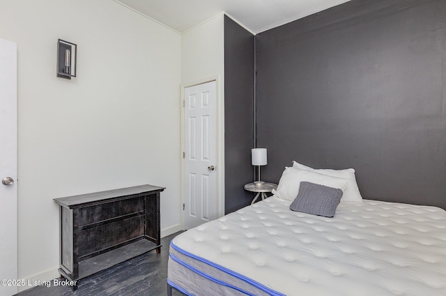 bedroom with dark wood finished floors and baseboards