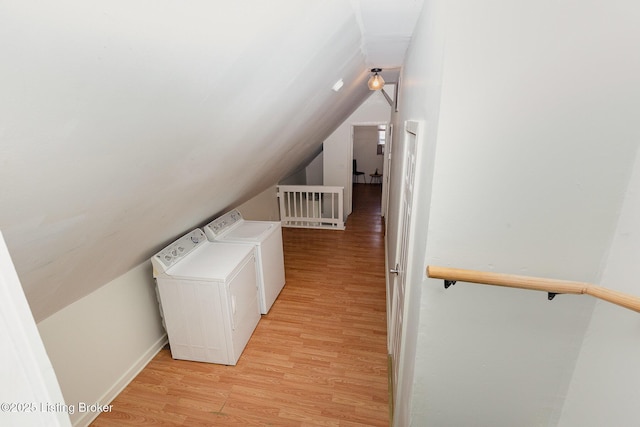 laundry room with washer and clothes dryer and light wood-style flooring