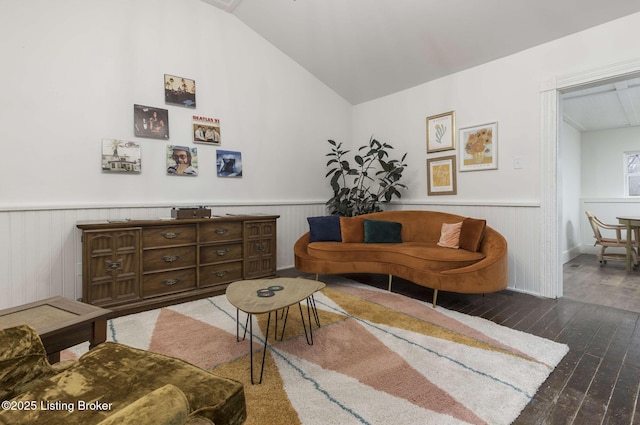 living area with a wainscoted wall, hardwood / wood-style flooring, and vaulted ceiling