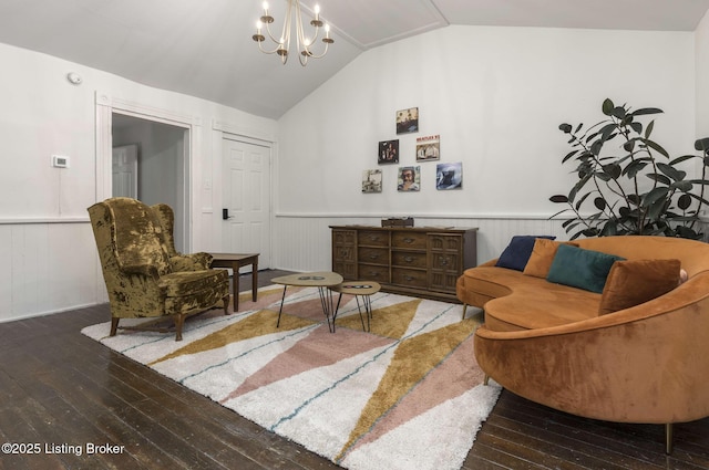 living area with a wainscoted wall, wood-type flooring, lofted ceiling, and an inviting chandelier