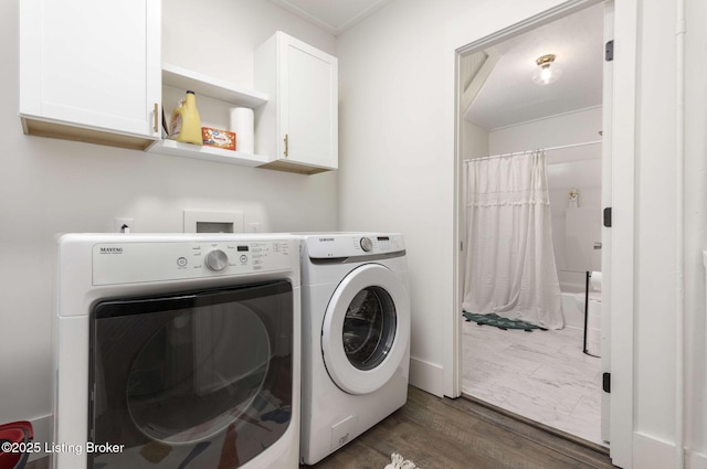 laundry room featuring cabinet space, separate washer and dryer, and wood finished floors