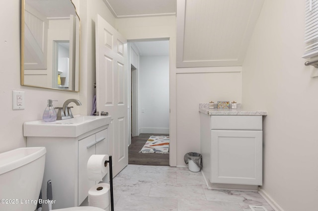 bathroom featuring baseboards, toilet, marble finish floor, and vanity