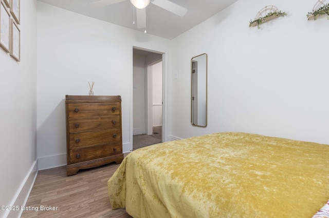 bedroom featuring baseboards, light wood-type flooring, and ceiling fan