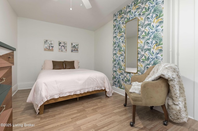 bedroom with light wood-type flooring, baseboards, and a ceiling fan