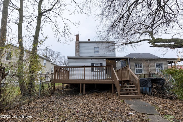 back of property featuring fence, a chimney, and a wooden deck