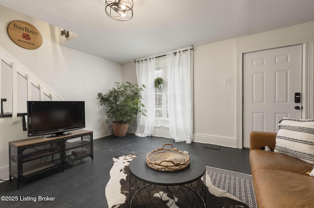 living room with baseboards and stairs