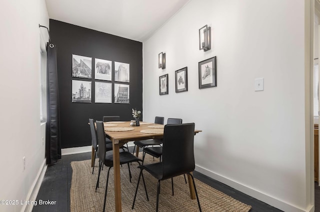 dining area featuring baseboards and dark wood-style flooring