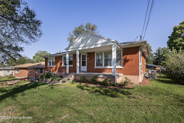 bungalow featuring brick siding, covered porch, and a front yard