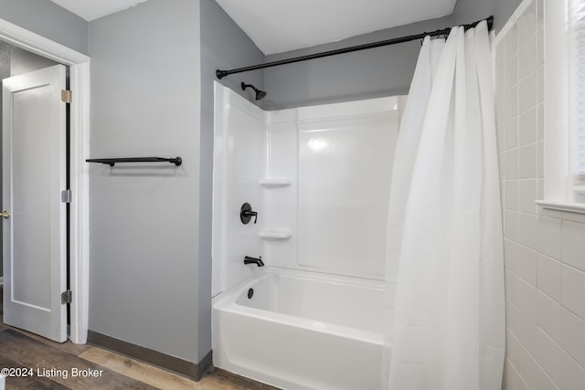 bathroom featuring baseboards and shower / tub combo