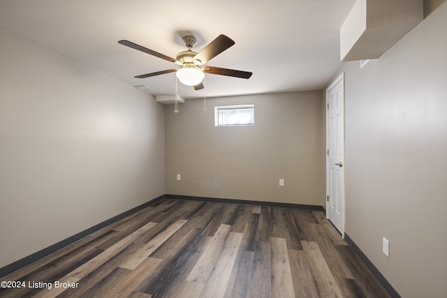 spare room featuring baseboards, dark wood finished floors, and a ceiling fan