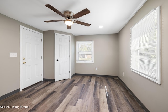 unfurnished bedroom featuring dark wood-style floors, baseboards, and ceiling fan