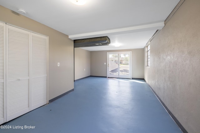 unfurnished room with finished concrete flooring and baseboards