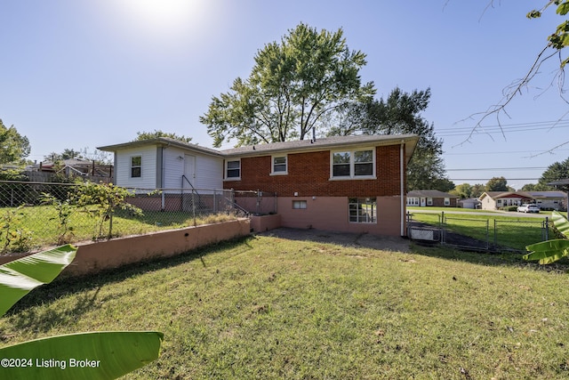 back of property with a yard, brick siding, and a fenced backyard