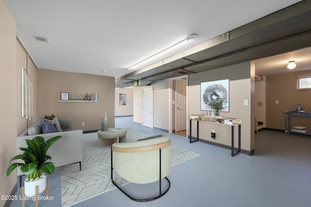 living area featuring visible vents, baseboards, and concrete flooring