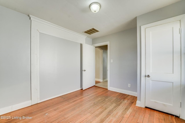 unfurnished bedroom featuring baseboards, visible vents, and light wood finished floors