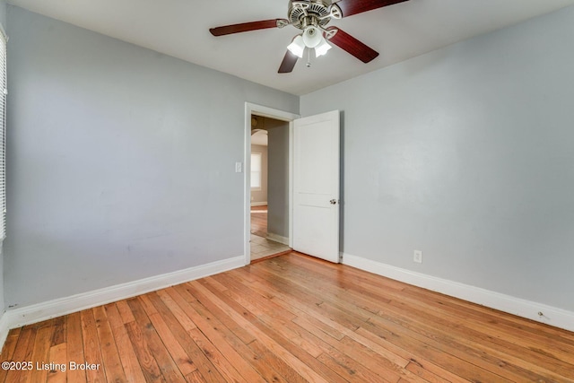 empty room with baseboards, light wood-style floors, and ceiling fan