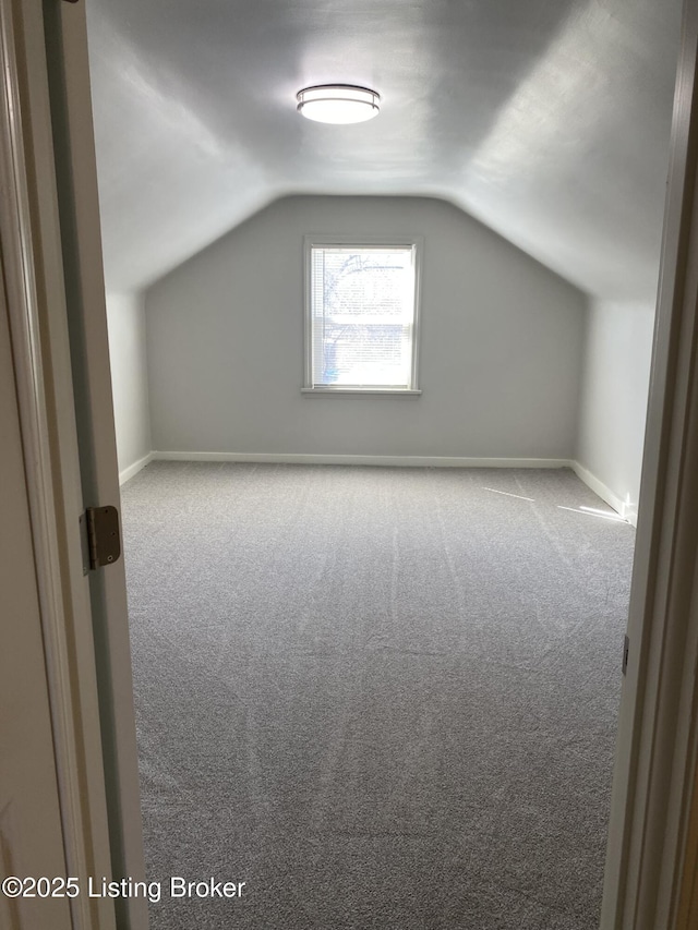 bonus room featuring lofted ceiling, baseboards, and carpet floors