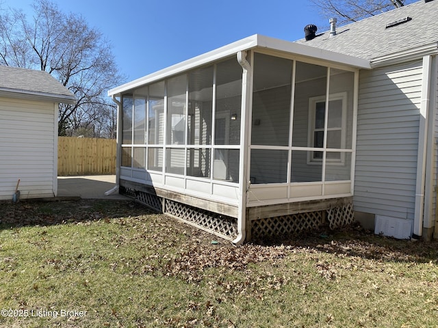 view of property exterior with a shingled roof and fence