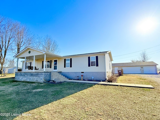 view of front of home with a porch, a detached garage, a front yard, and an outdoor structure