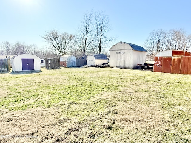 view of yard with a shed, an outdoor structure, and fence