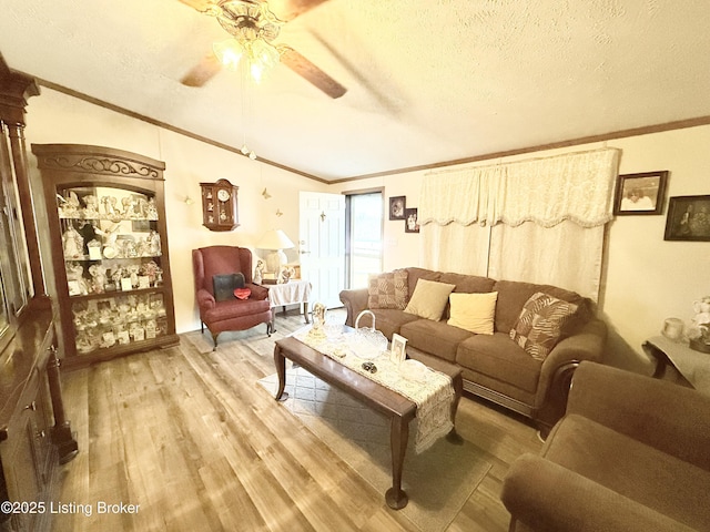 living area featuring ceiling fan, wood finished floors, a textured ceiling, and ornamental molding