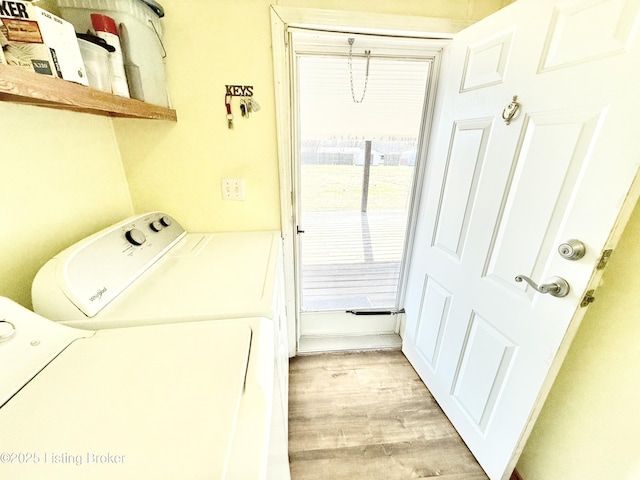 laundry area with light wood-type flooring, laundry area, and washer and clothes dryer