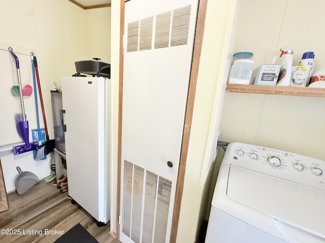 clothes washing area with wood finished floors, visible vents, laundry area, washer / clothes dryer, and a heating unit